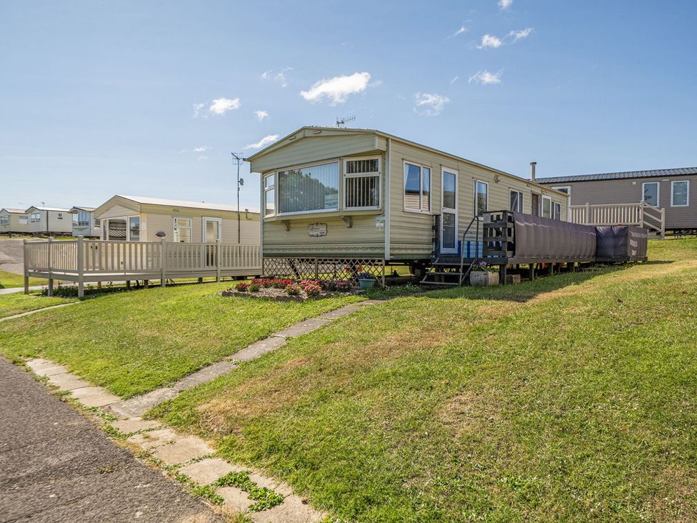 A mobile home with a deck and pathway at 3 Bed Sleeps 8 Sea View Pets Parking Reighton Gap near Filey