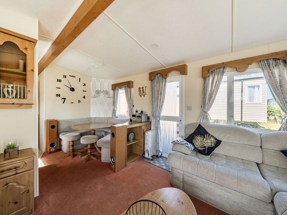 A living room with a sofa and dining table at 3 Bed Sleeps 8 Sea View Pets Parking Reighton Gap near Filey