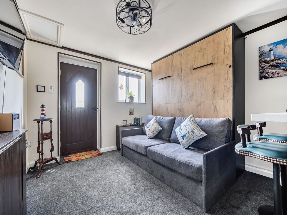 A living room with a door and a sofa at Studio Sleeps 2 with Parking and Garden Trewidland near Liskeard