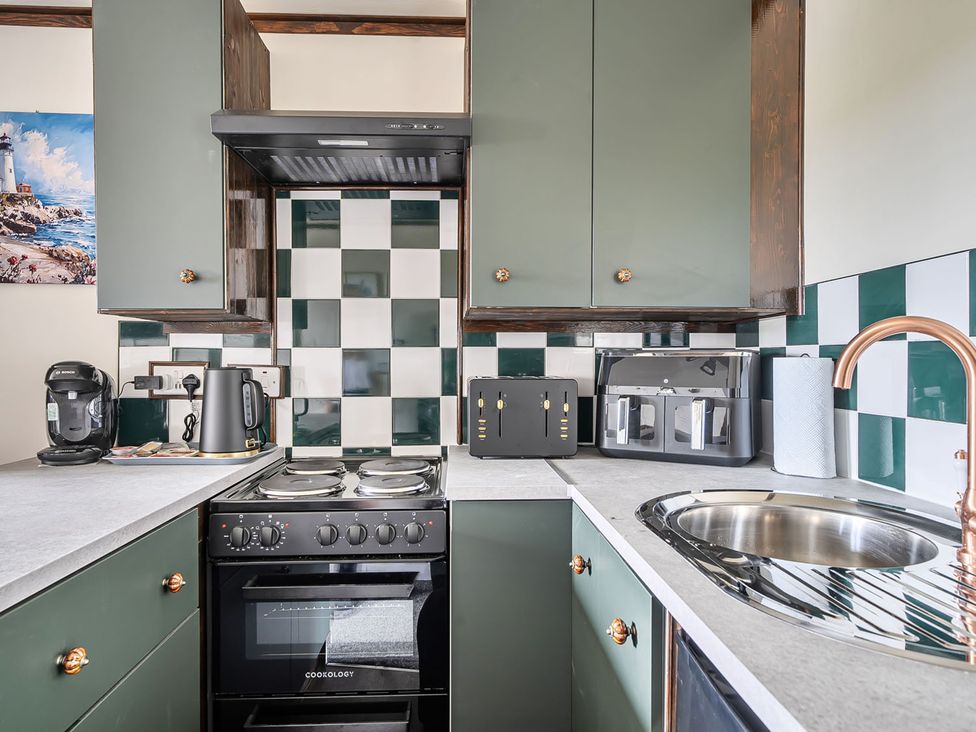 A kitchen with appliances including a stove, sink, and coffee maker at Studio Sleeps 2 with Parking and Garden Trewidland near Liskeard