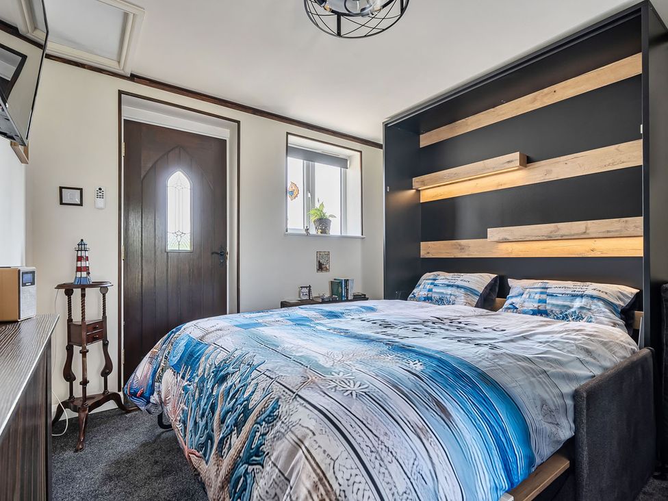 A bedroom with a bed and side table at Studio Sleeps 2 with Parking and Garden Trewidland near Liskeard