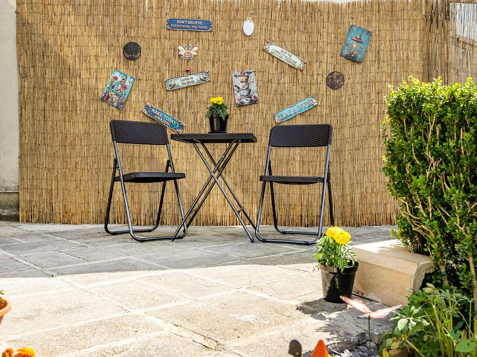 A table and two chairs in an outdoor area at Studio Sleeps 2 with Parking and Garden Trewidland near Liskeard
