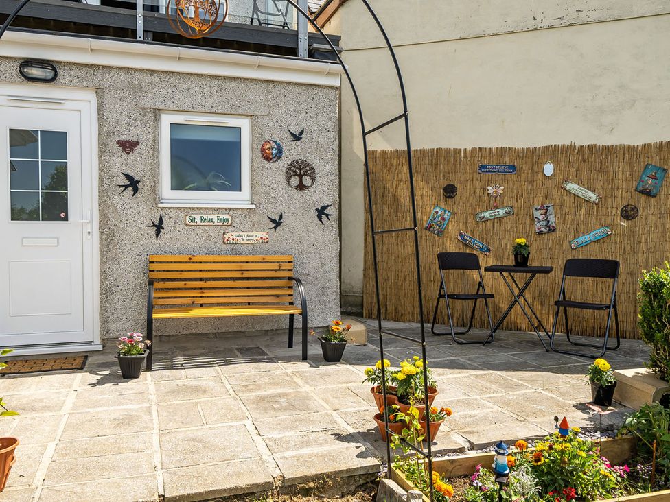 An outdoor seating area with a bench, table, and chairs at Studio Sleeps 2 with Parking and Garden, Trewidland near Liskeard