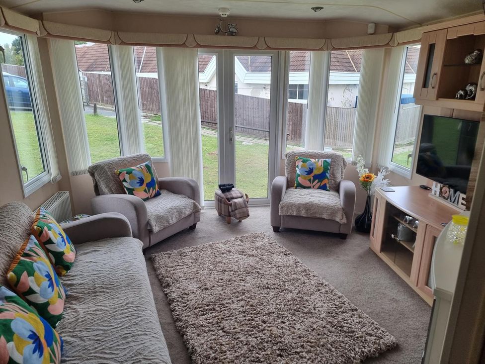 A snug with sofas and a television at Chalet Sleeps 6 swimming pool Thorness Bay