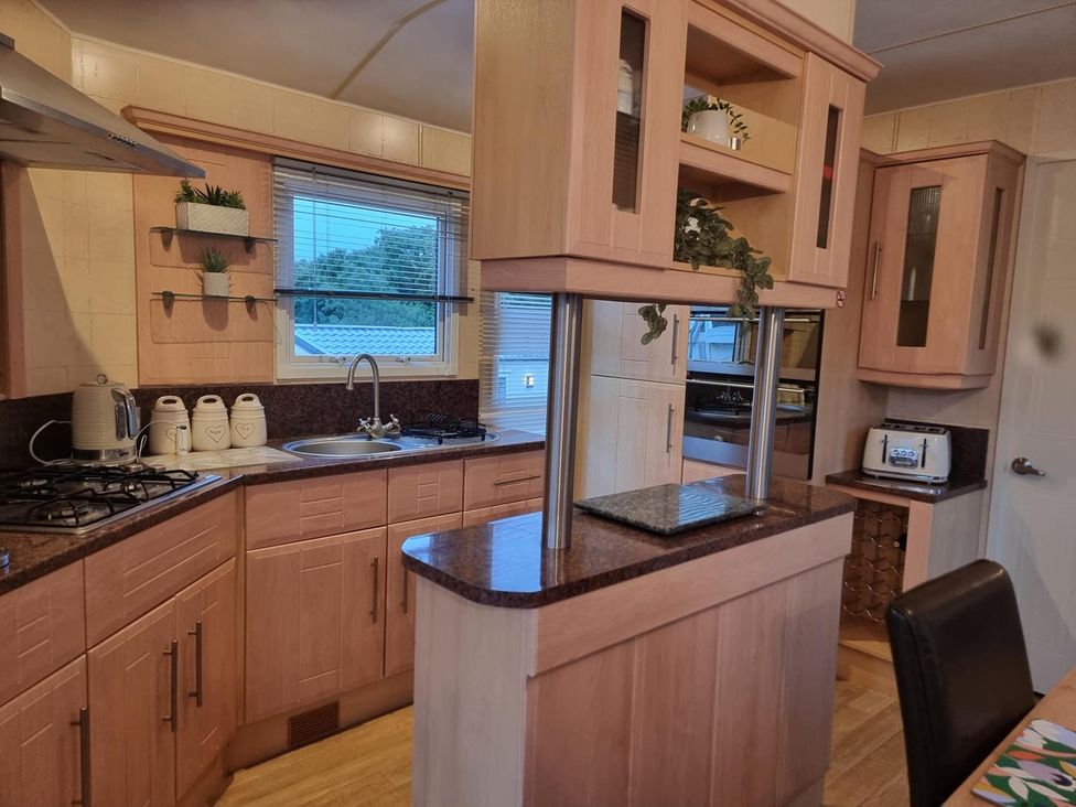 A kitchen with cabinets and appliances at Chalet Sleeps 6 swimming pool Thorness Bay