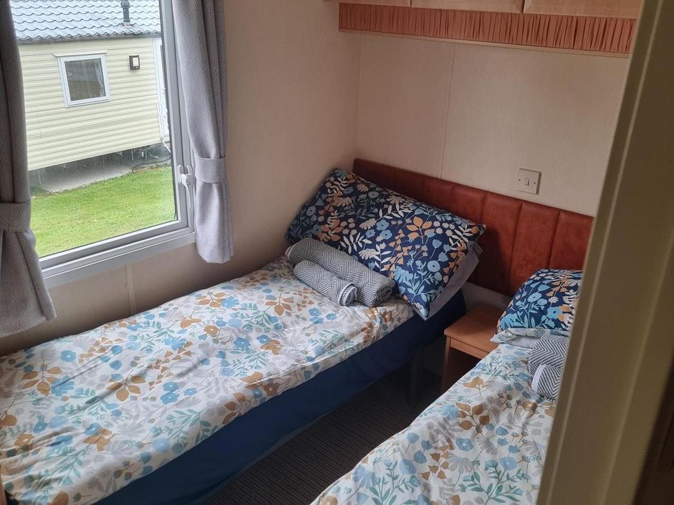 A bedroom with twin beds and a window at Chalet Sleeps 6 swimming pool Thorness Bay