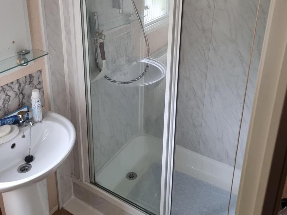 A bathroom with a shower and sink at Chalet Sleeps 6 swimming pool Thorness Bay