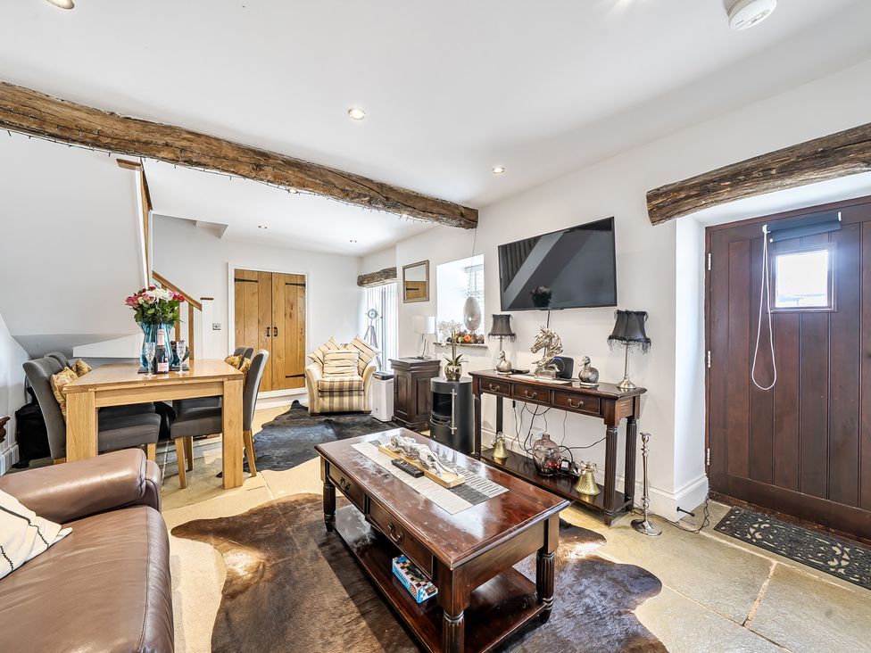 A living room with a sofa, dining table, and television at Barn Sleeps 4 Parking Near Alton Towers Waterhouses