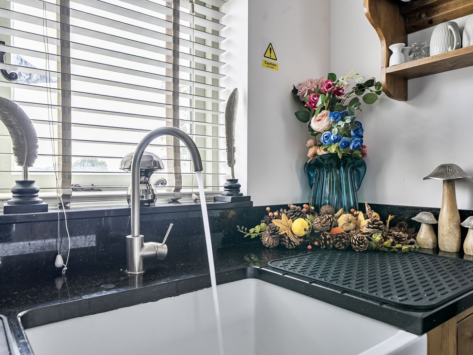 A kitchen sink with a faucet and decorative flowers at Barn Sleeps 4 Parking Near Alton Towers Waterhouses