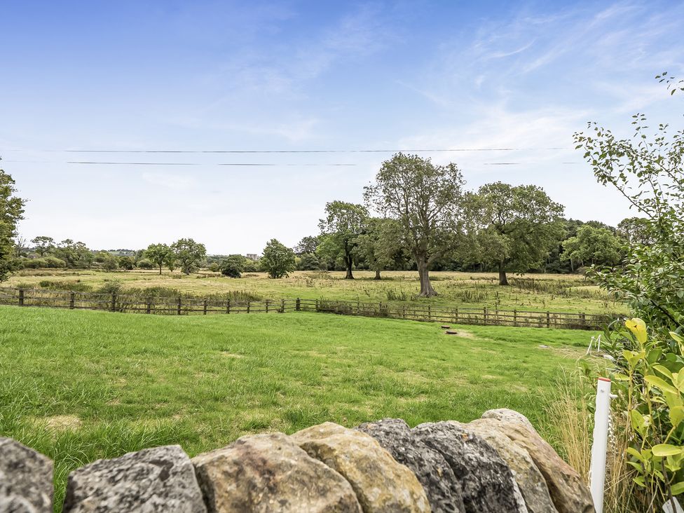 A grassy field with trees and a stone wall at Barn Sleeps 4 Parking Near Alton Towers Waterhouses