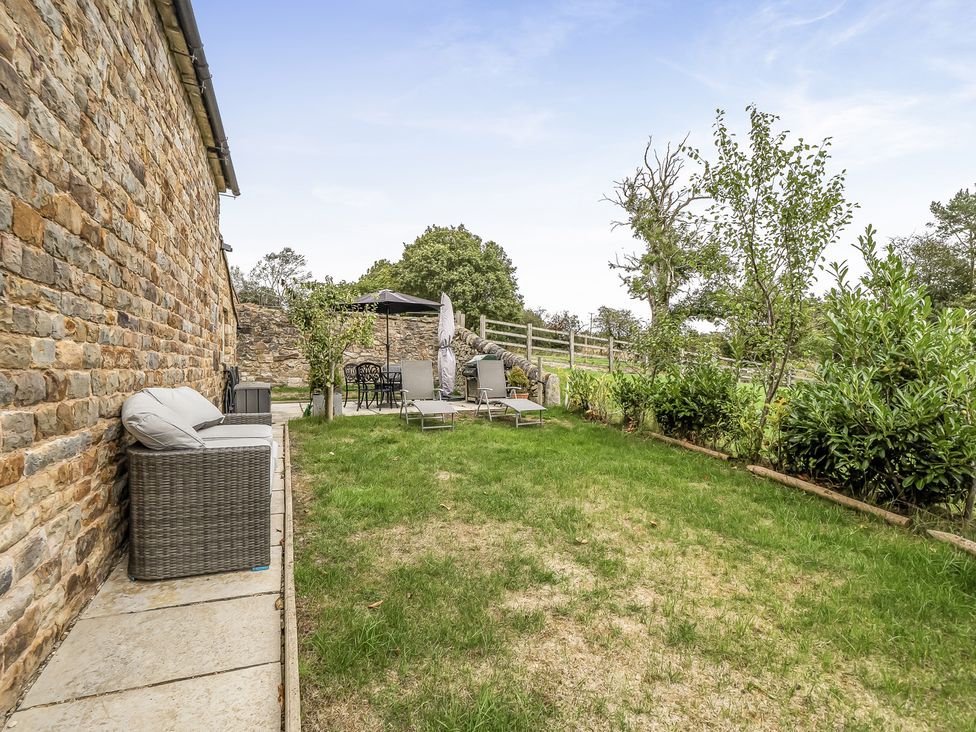 A garden with seating and umbrella at Barn Sleeps 4 Parking Near Alton Towers Waterhouses