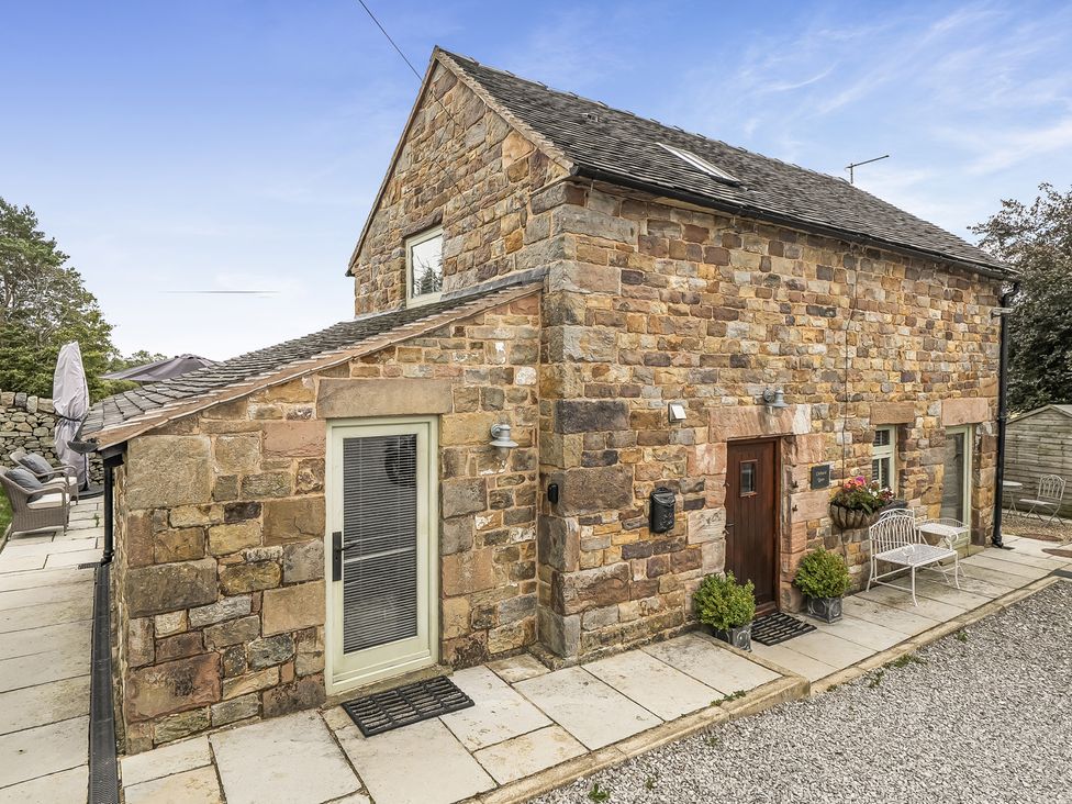 An outdoor view of a stone cottage with patio furniture at Barn Sleeps 4 Parking Near Alton Towers Waterhouses