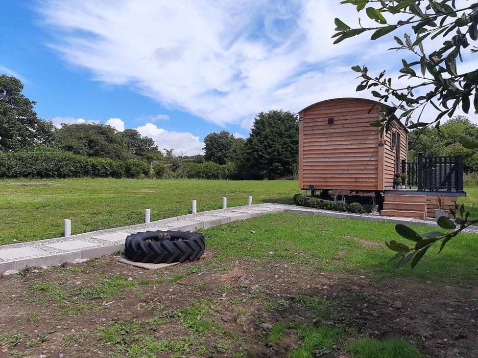 An outdoor area with a wooden cabin and a tire at Min yr Afon Cabin Sleeps2 Hot Tub Parking in Gwalchmai