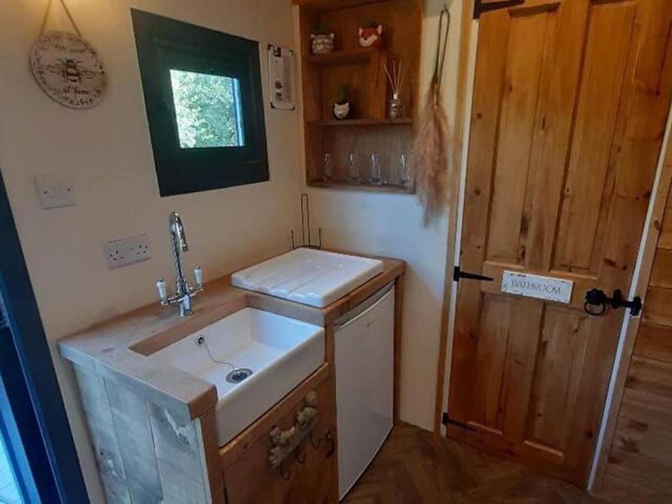 A sink with cabinet and refrigerator at Min yr Afon Cabin Sleeps2 Hot Tub Parking Gwalchmai