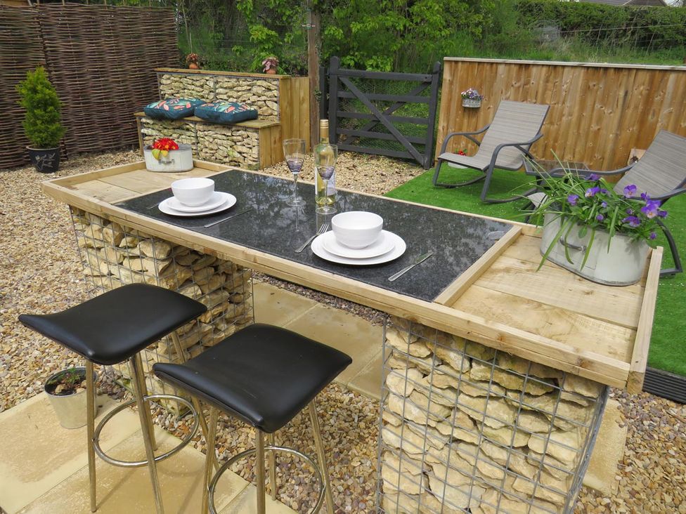 A garden with a table and stools at a property
