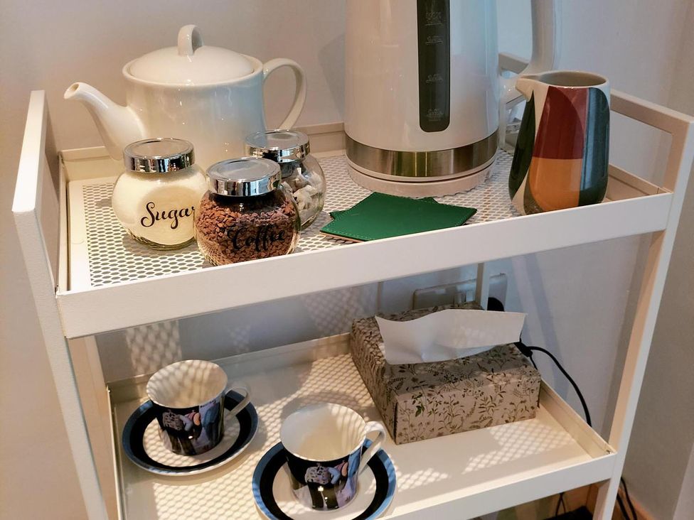 A kitchen cart with tea and coffee supplies and cups at the property