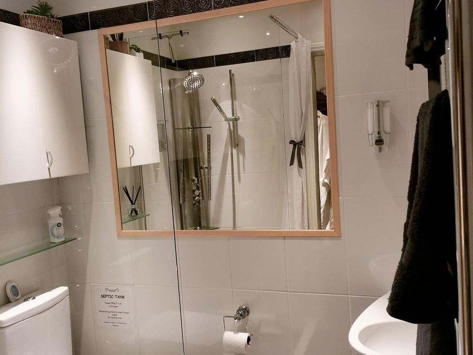 A bathroom with a shower, toilet, and sink at The Old Barn in Manchester