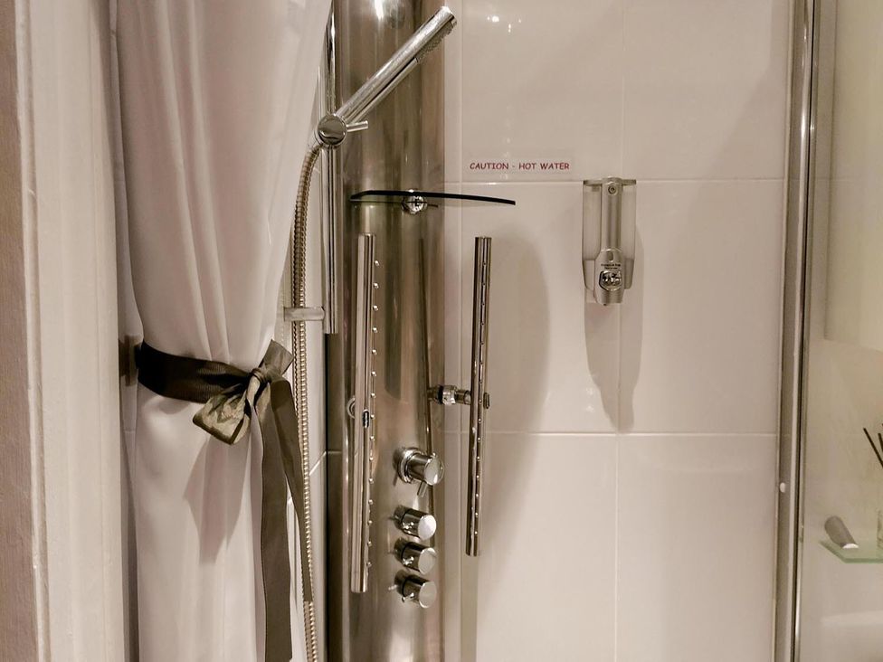 A shower panel with control features in a bathroom