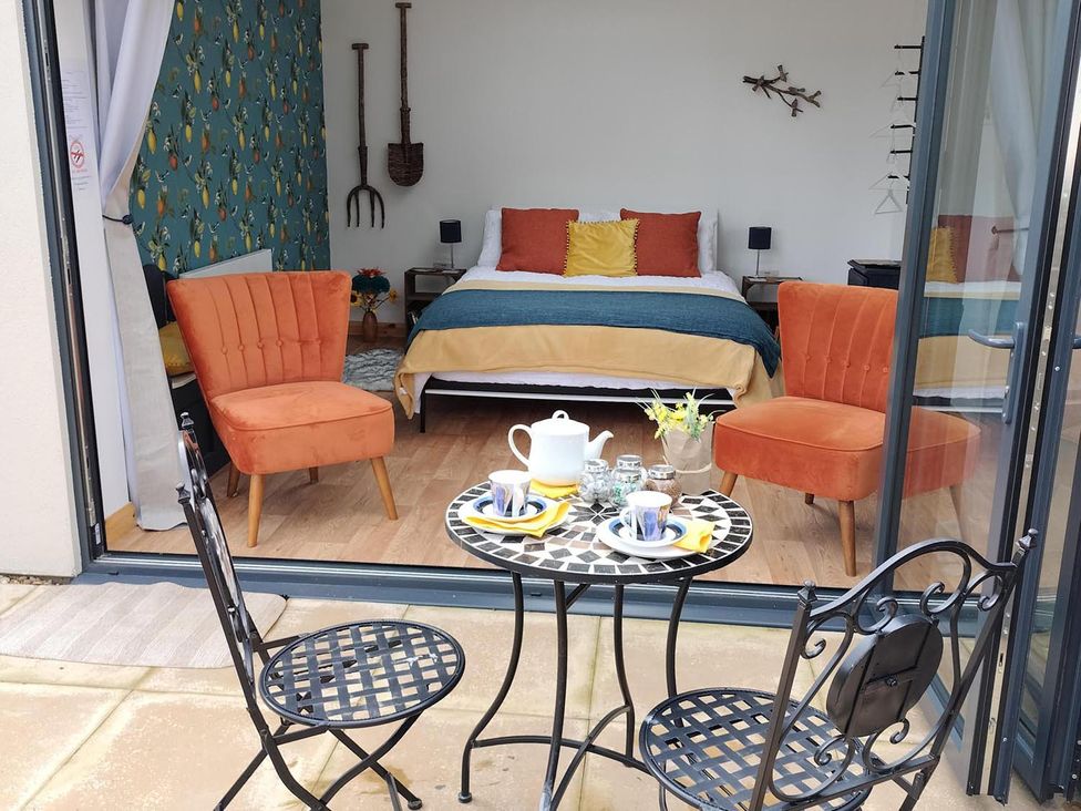 A bedroom with a bed and chairs at 