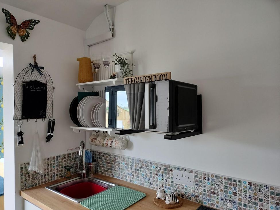 A kitchen with a microwave and sink at The Garden Room in 
