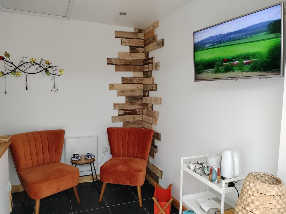 A sitting room with two chairs and a television at a property