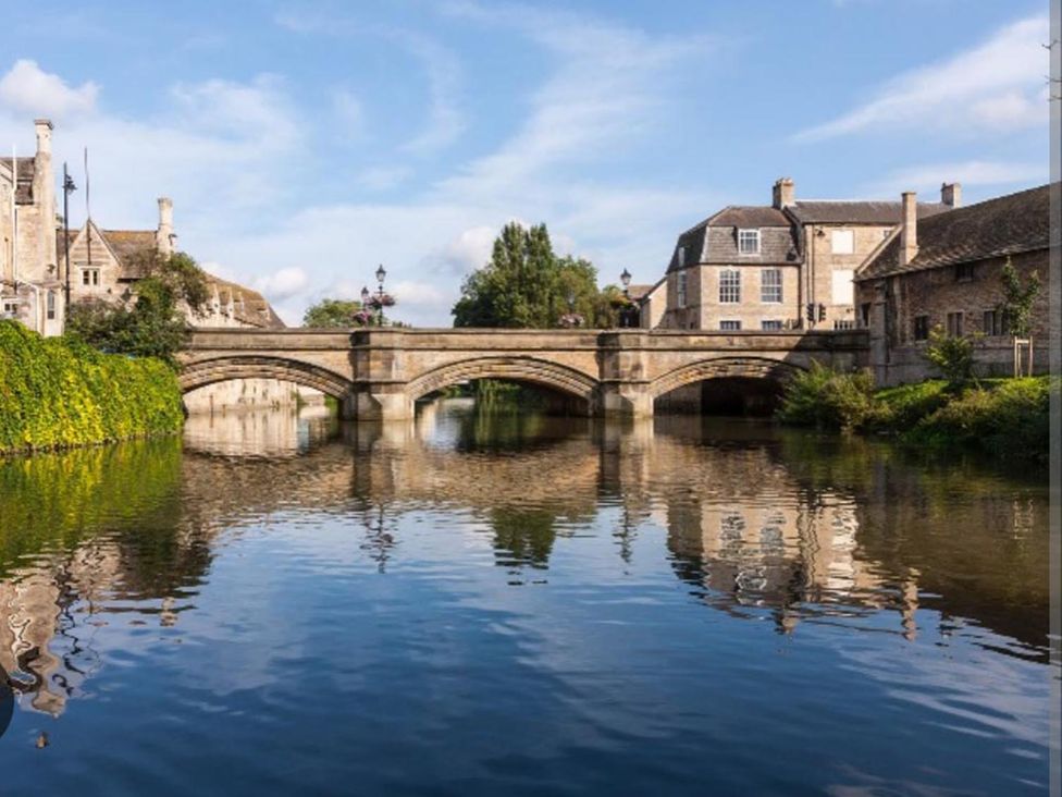 A bridge over water with buildings and trees at a scenic location