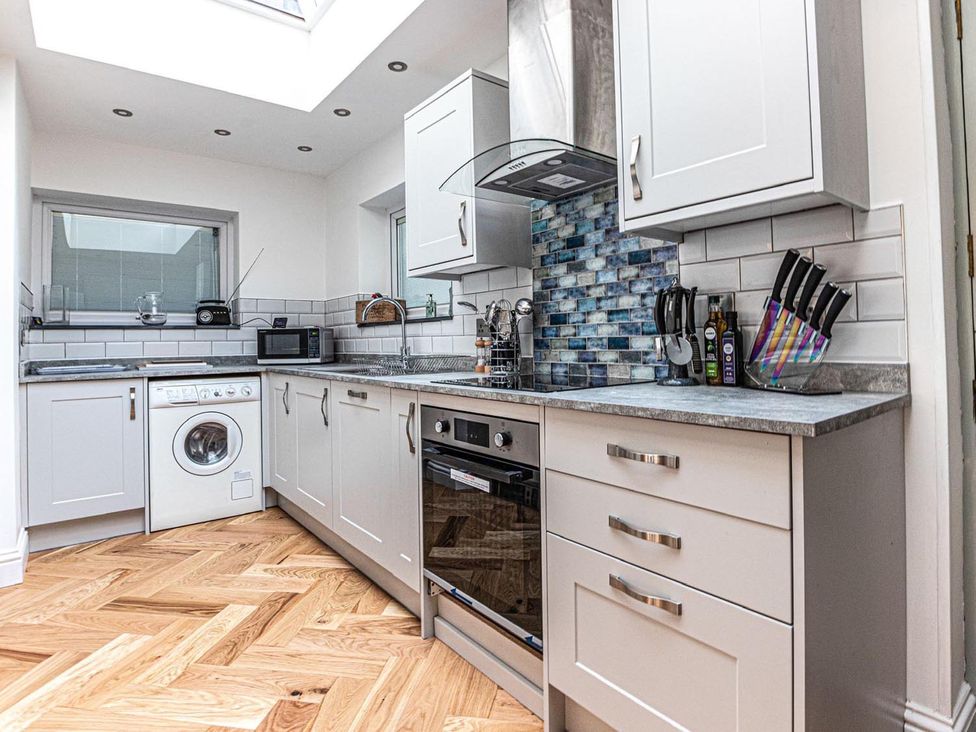 A kitchen with cabinets, appliances and utensils at The Slipway Fowey Harbour with Garden in Fowey