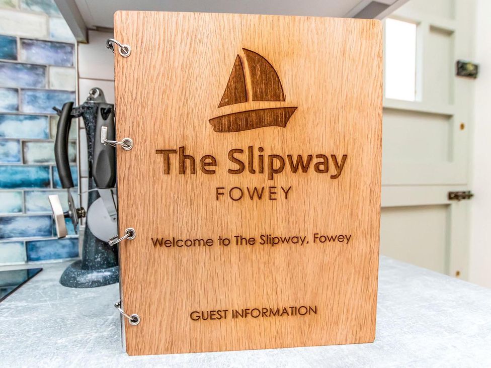 A wooden sign with guest information at The Slipway Fowey Harbour with Garden in Fowey