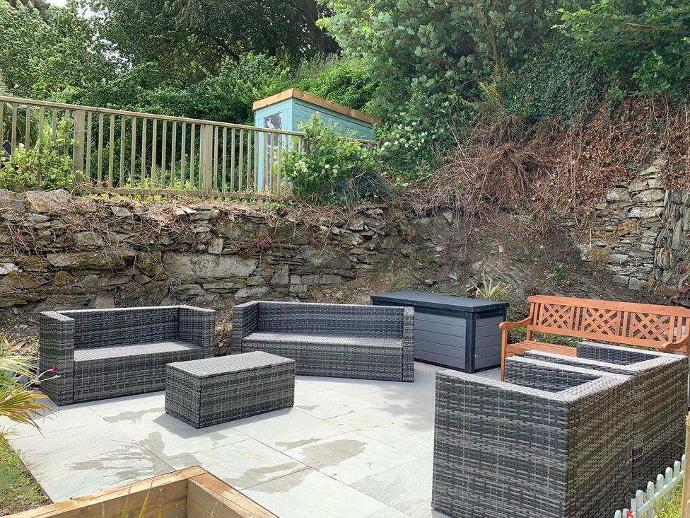 A garden with outdoor furniture and a rock wall at The Slipway Fowey Harbour with Garden Fowey