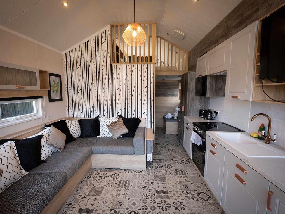 A living room with a sofa and kitchen unit at Selfcatering Lodge Inverness Sleeps 4 Inverness