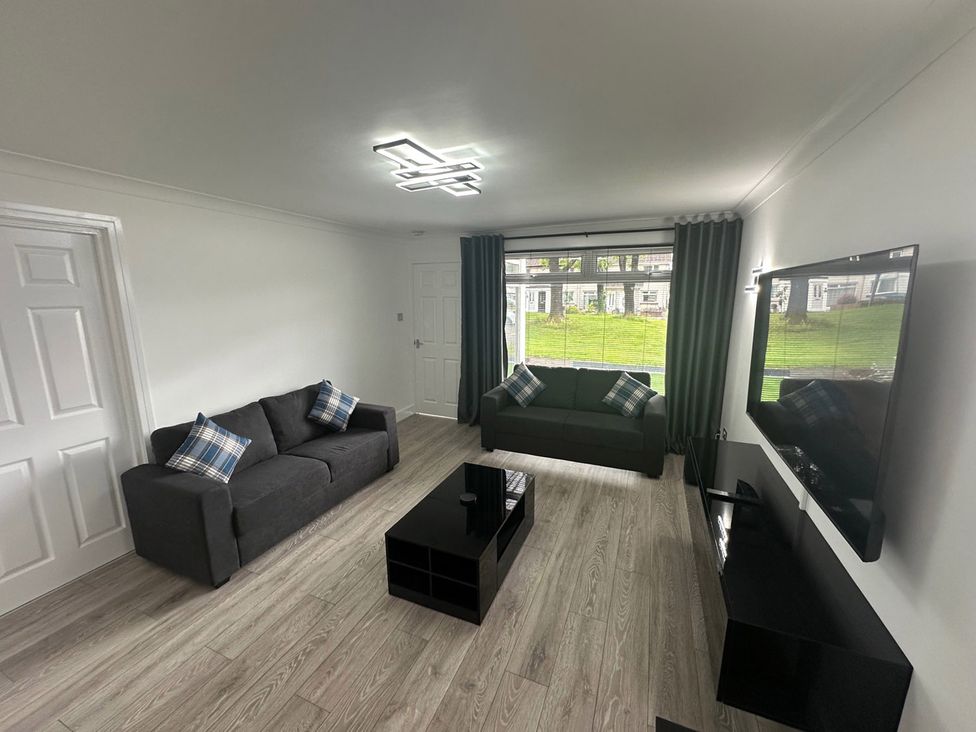 A living room with sofas and a television at Family Garden Parking WiFi Sleeps 5 in Alloa