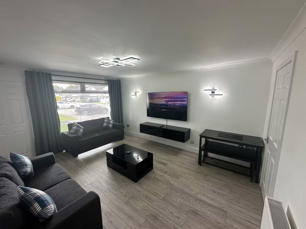 A living room with a sofa and television at Family Garden Parking WiFi Sleeps 5, Alloa
