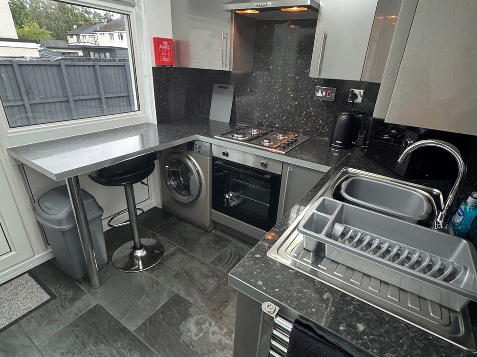 A kitchen with appliances and a countertop at Family Garden Parking WiFi Sleeps 5 Alloa