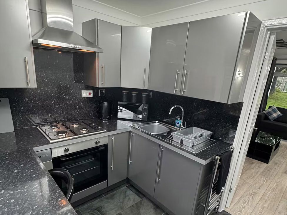 A kitchen with appliances and a sink at Family Garden Parking WiFi Sleeps 5 in Alloa