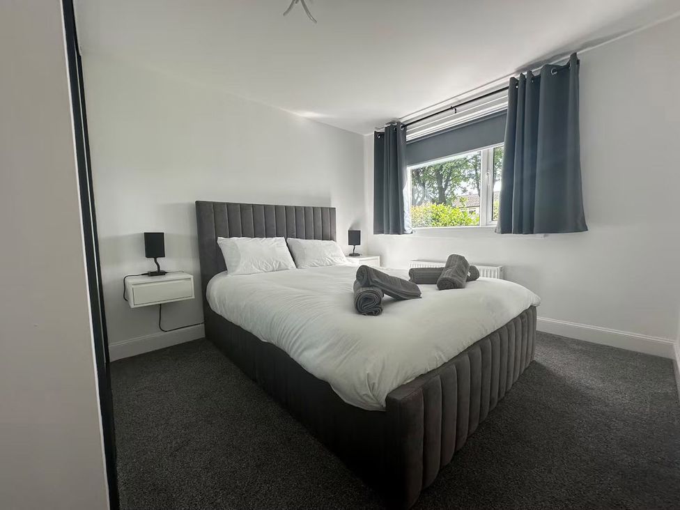 A bedroom with a bed and bedside table at Family Garden Parking WiFi Sleeps 5 in Alloa