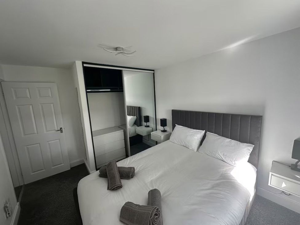 A bedroom with a bed and wardrobe at Family Garden Parking WiFi Sleeps 5 in Alloa