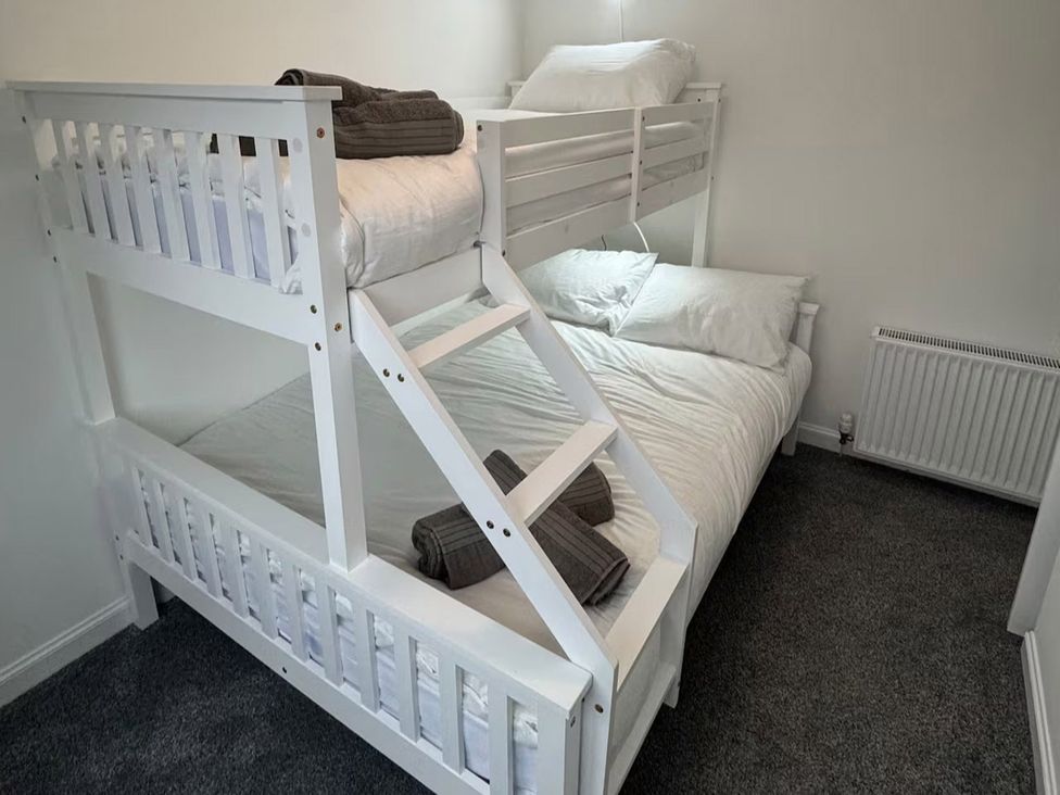 A bunk bed with a double mattress and bedding at Family Garden Parking WiFi Sleeps 5 in Alloa