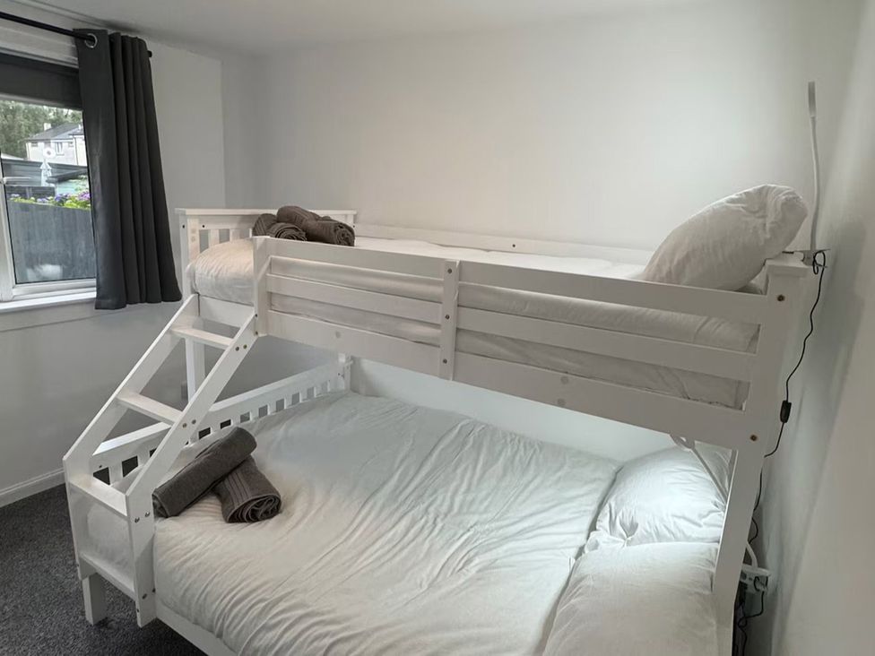 A bedroom with a bunk bed and window at Family Garden Parking WiFi Sleeps 5 in Alloa