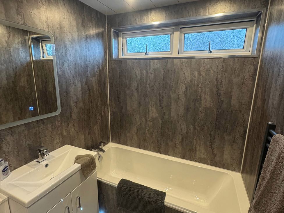 A bathroom with a bathtub and sink at Family Garden Parking WiFi Sleeps 5 Alloa