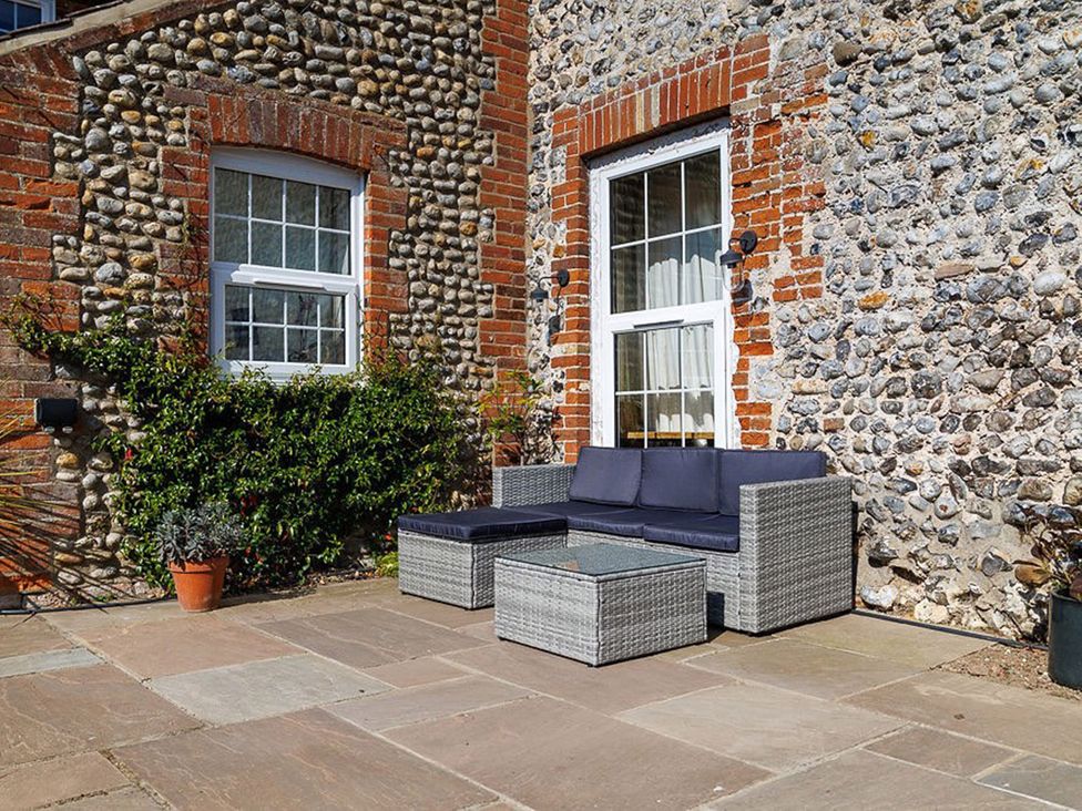 An outdoor seating area with a sofa and coffee table at North Norfolk Garden Retreat with Private Hot Tub, Crossdale Street near Cromer