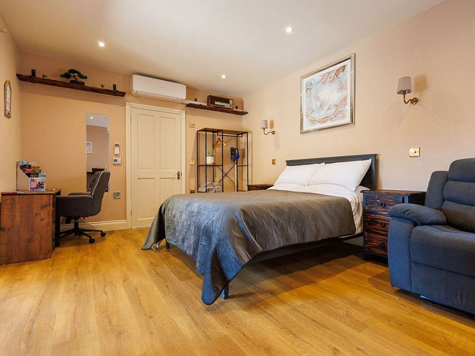 A bedroom with a bed and desk at North Norfolk Garden Retreat with Private Hot Tub Crossdale Street near Cromer