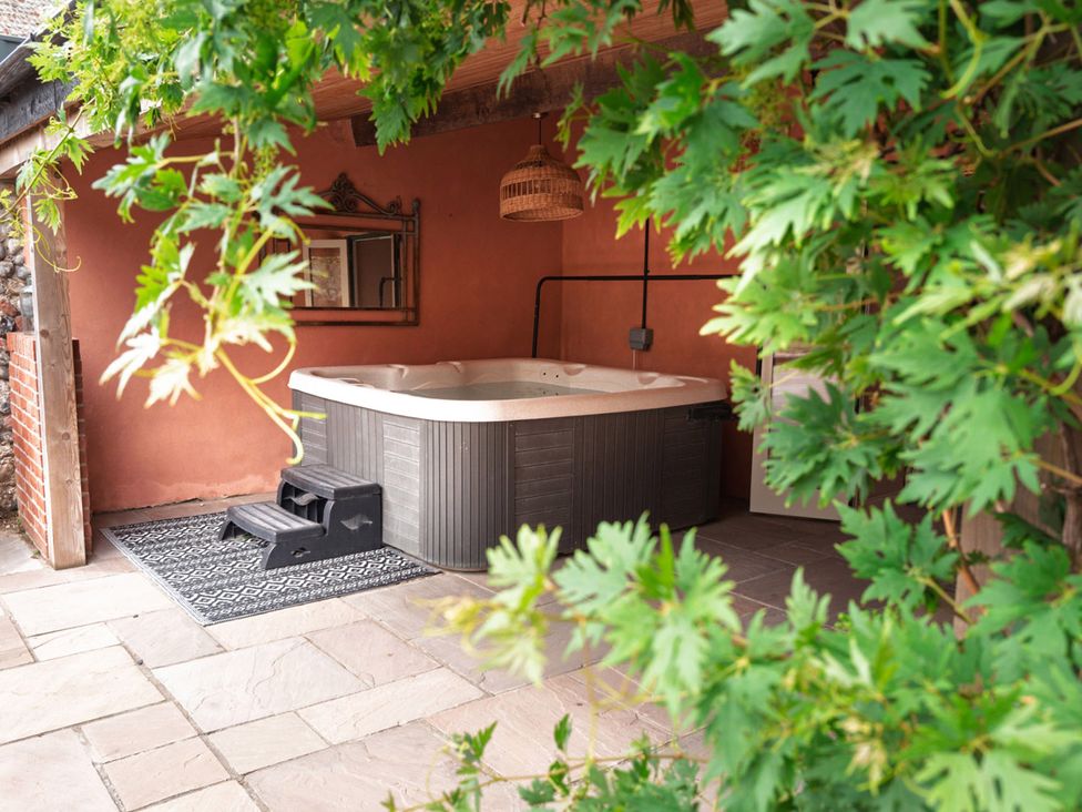 A hot tub with steps and a mirror in an outdoor space at North Norfolk Garden Retreat with Private Hot Tub Crossdale Street near Cromer