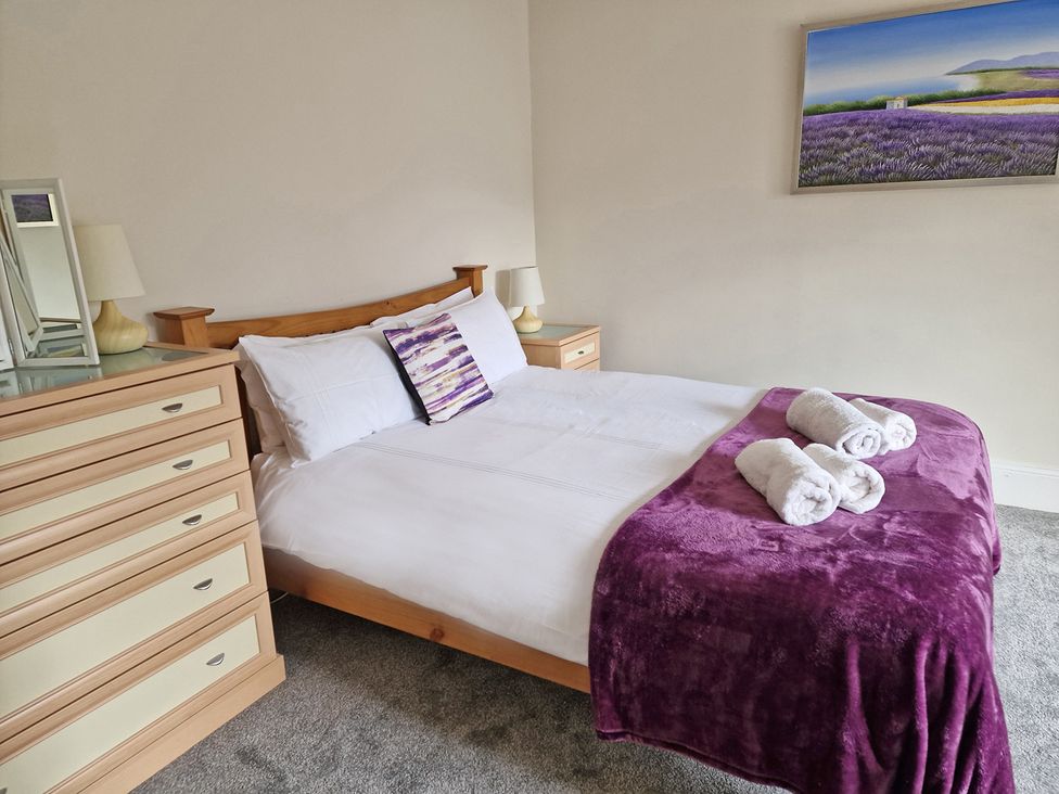 A bedroom with a bed, dresser, and lamps at The Old Barn in Manchester