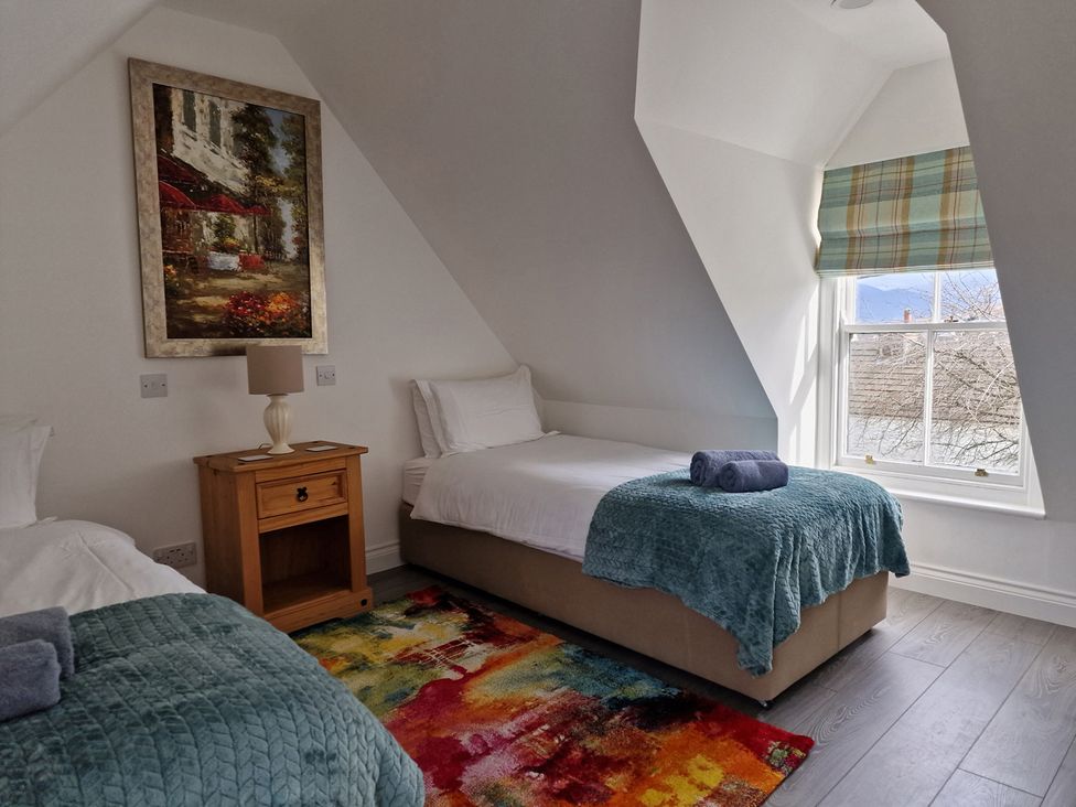 A bedroom with two beds and a painting at an unknown location