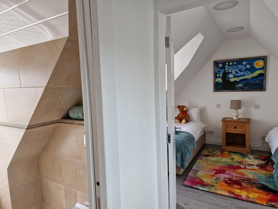 A bedroom with beds, a nightstand, and an adjoining bathroom at 