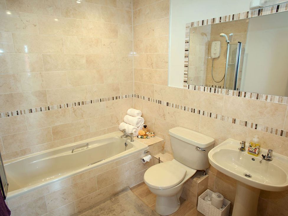 A bathroom with a bathtub, toilet, and sink at The Old Barn in Manchester