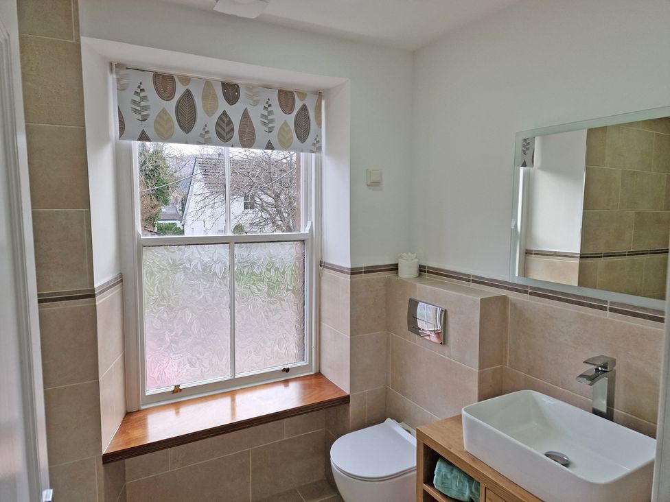 A bathroom with a sink, toilet, and window at 