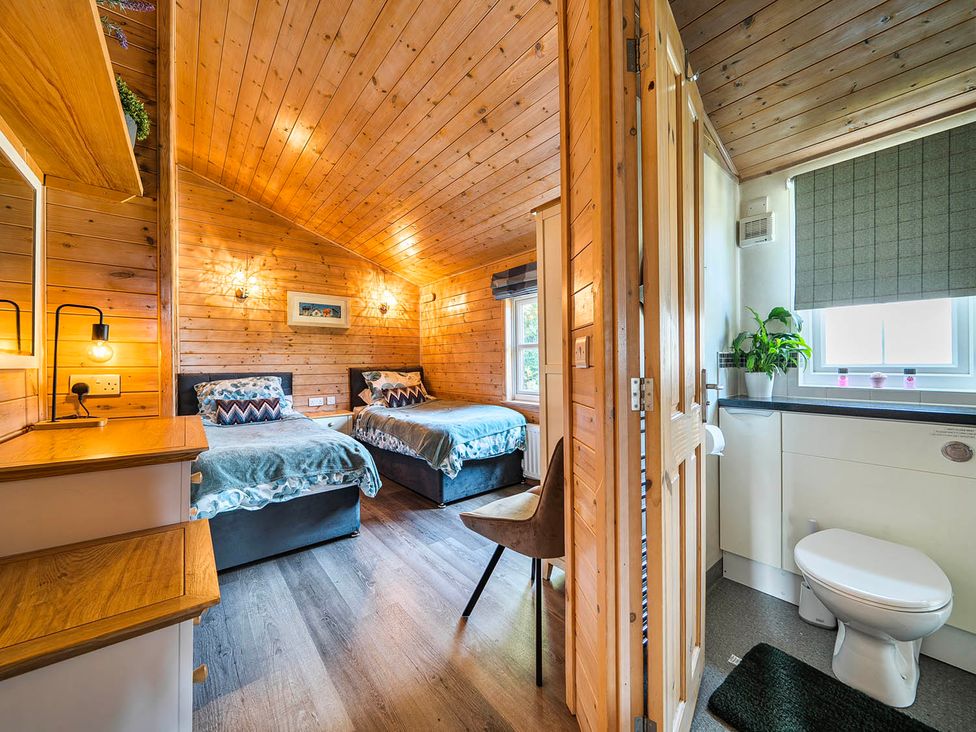 A bedroom with two beds and a bathroom at Alpaca Farm Valley Views Sleeps 4 Parking Pets in Husthwaite