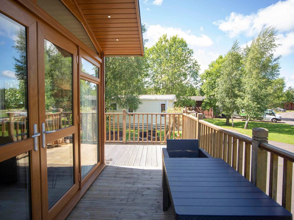 An outdoor deck with a table and chairs at Felmoor Park Northumberland Lodge with Hot Tub Felmoor Park near Felton