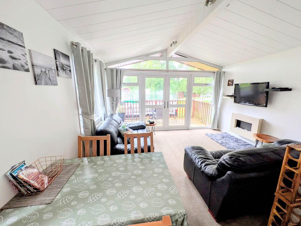 A living room with a sofa, dining table and television at Felmoor Park Northumberland Lodge with Hot Tub, Felmoor Park near Felton